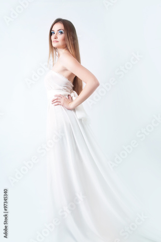 Pretty slim young woman in a long white dress