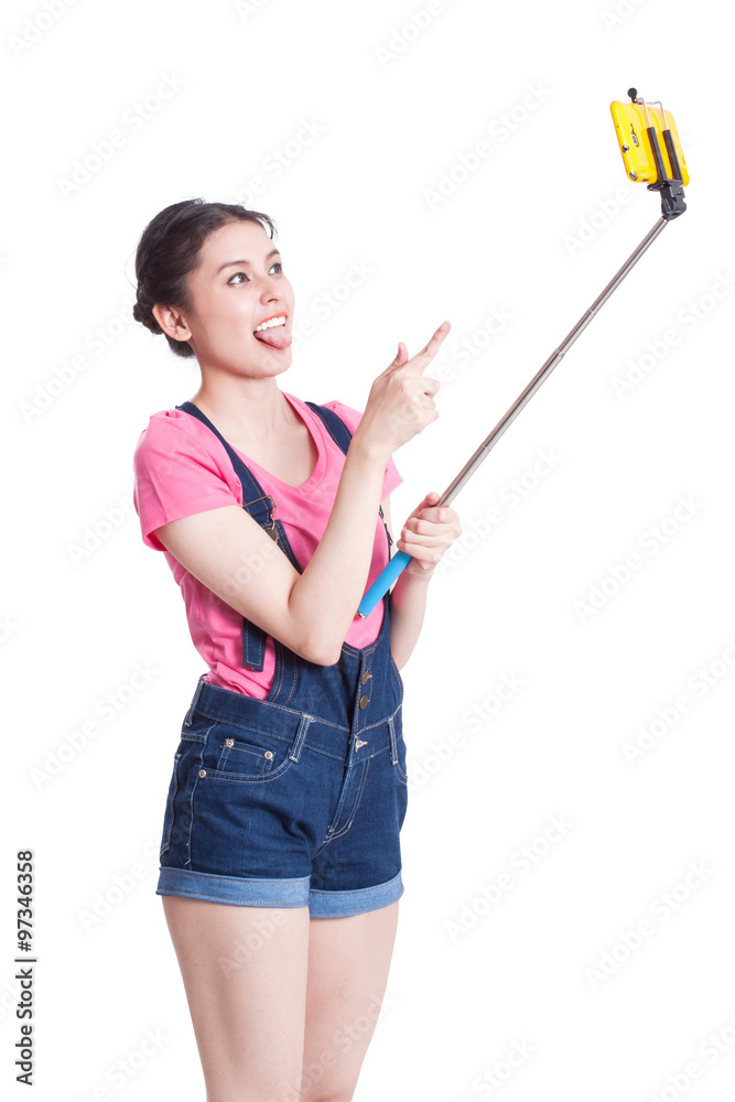 Young woman taking picture with smartphone selfie stick Young woman taking picture with smartphone selfie stick