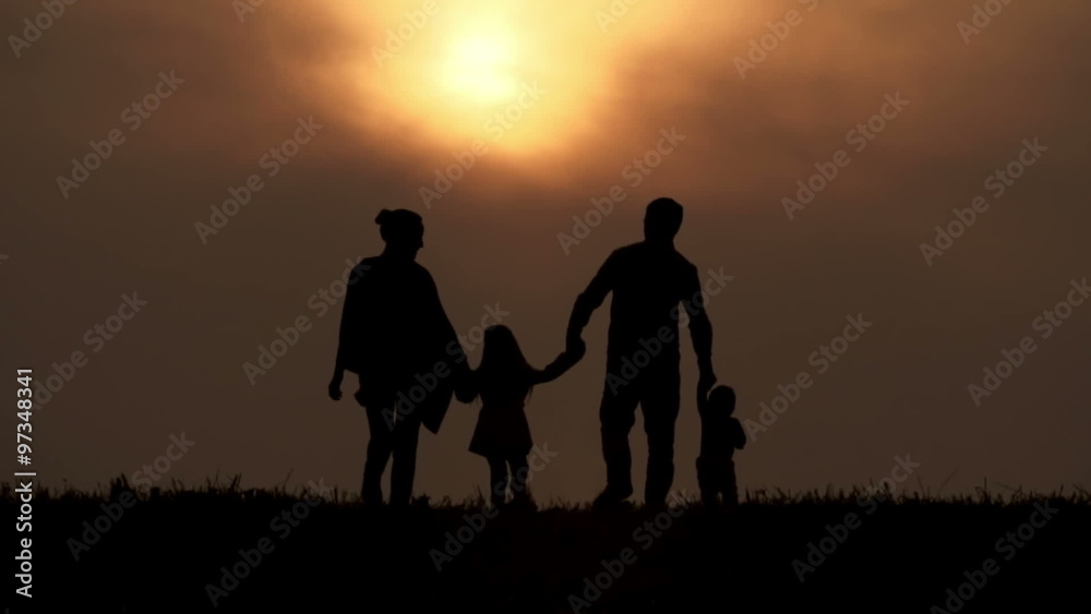 Rear view of silhouettes of mother and dad walking with their kids towards sunset Rear view of silhouettes of mother and dad walking with their kids towards sunset