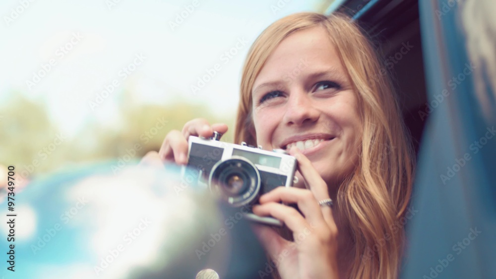 Handheld shot of blonde girl taking photo from car with a vintage film camera
Handheld shot of blonde girl taking photo from car with a vintage film camera