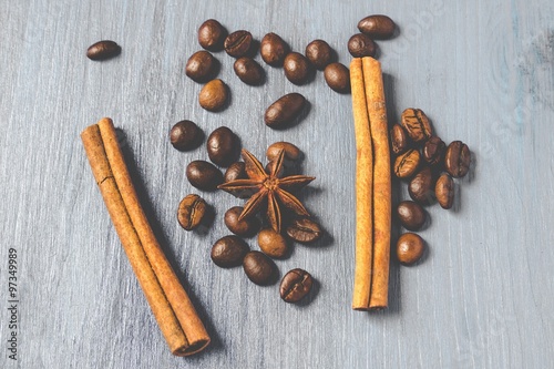 Coffee beans, cinnamon sticks and star anise on gray wooden table, with matte effect