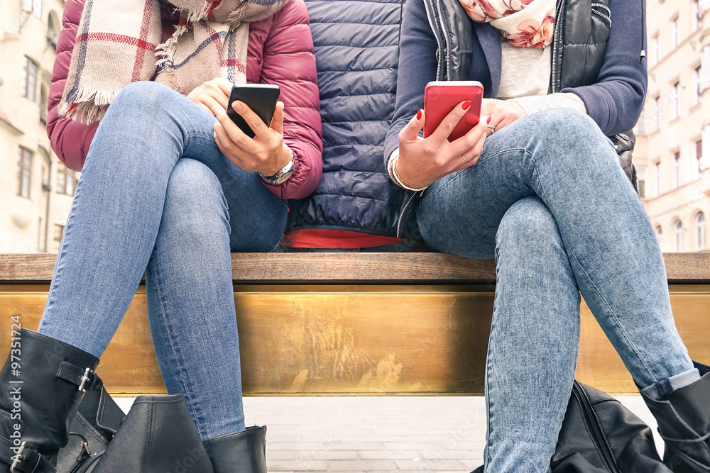 Close up of couple of girlfriends in disinterest moment with mobile smart phones - Concept of relationship apathy sadness and isolation using new technology - Female friends with smartphone addiction Close up of couple of girlfriends in disinterest moment with mobile smart phones - Concept of relationship apathy sadness and isolation using new technology - Female friends with smartphone addiction