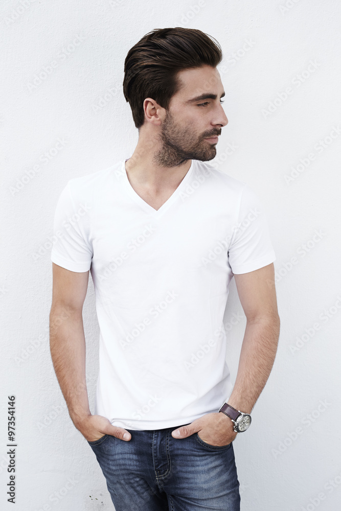 Young man in white t-shirt against white wall