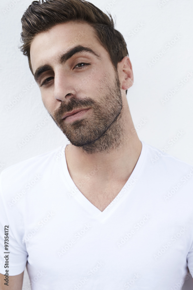 Fototapeta premium Portrait of quizzical young man in white