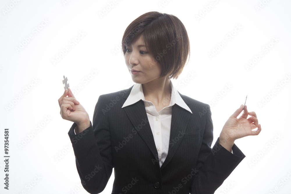 パズルピースを持つ女性会社員 パズルピースを持つ女性会社員