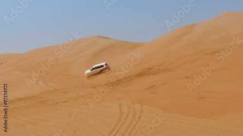 4WD car driving with speed over dunes in oman desert Rub al Khali, the second largest sand desert in the world, also called empty quarter 4K UHD photo