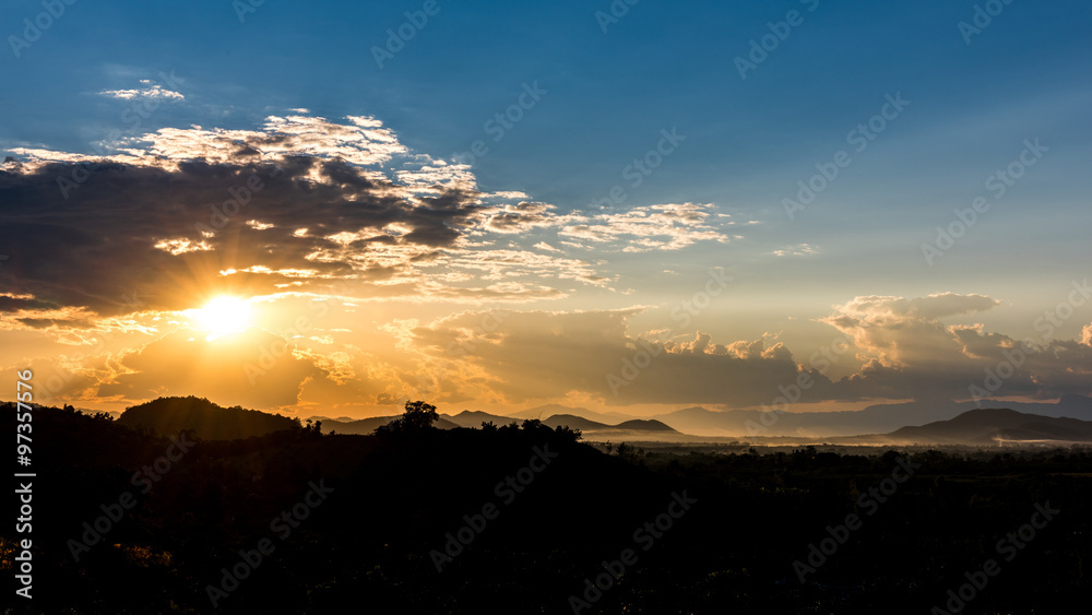 Fototapeta premium Crepuscular sun rays during sunset over the hill