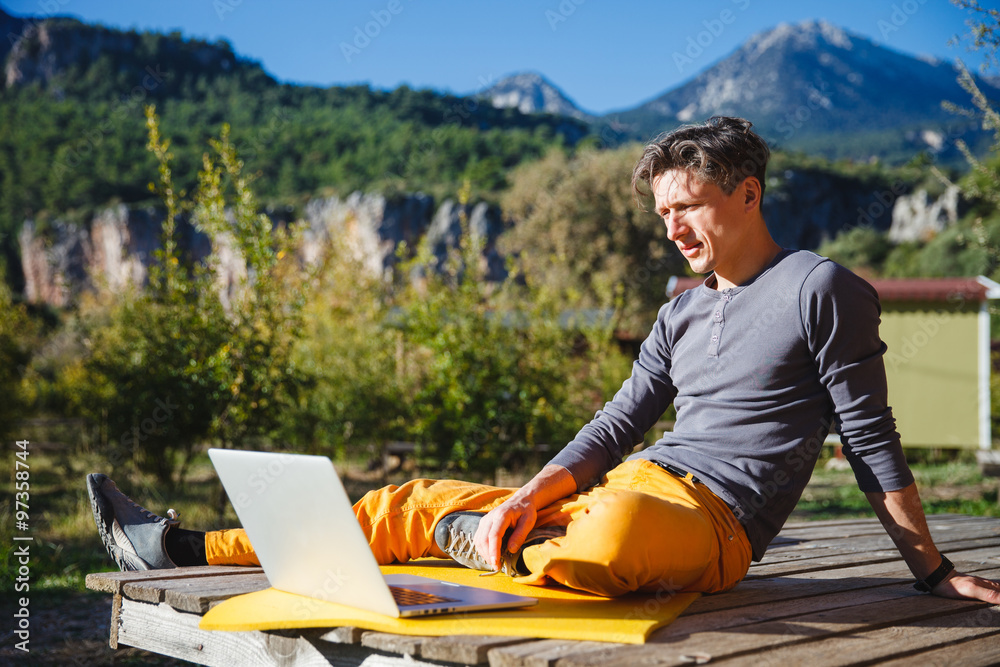 Freelancer working on computer over the mountain landscape