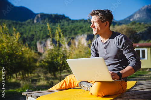 Freelancer working on computer over the mountain landscape © serhiipanin