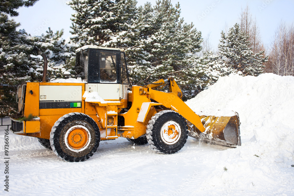 Wheel loader is cleaning a road from snow Wheel loader is cleaning a road from snow
