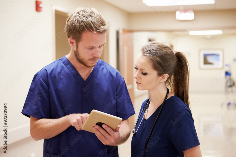 Obraz premium Medical Staff Looking At Digital Tablet In Hospital Corridor