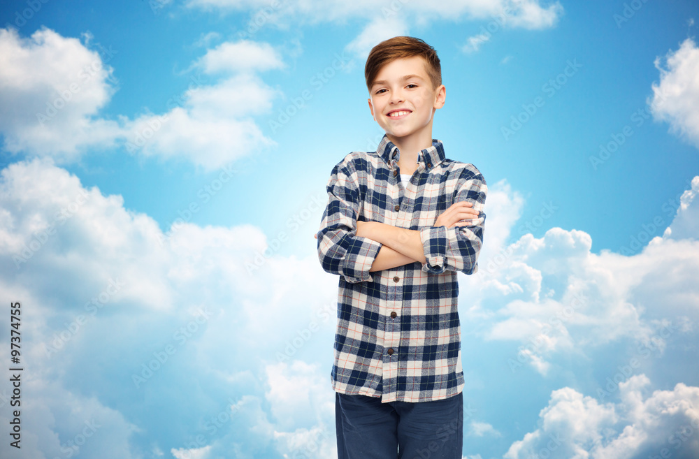 smiling boy in checkered shirt over blue sky smiling boy in checkered shirt over blue sky
