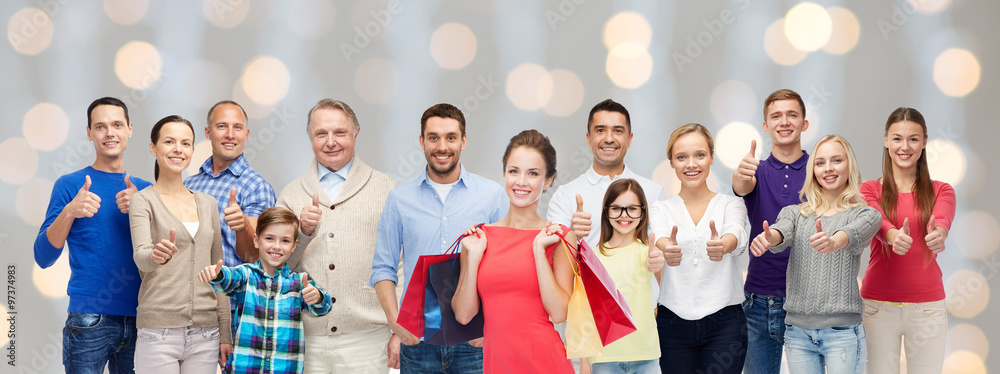 happy people with shopping bags showing thumbs up