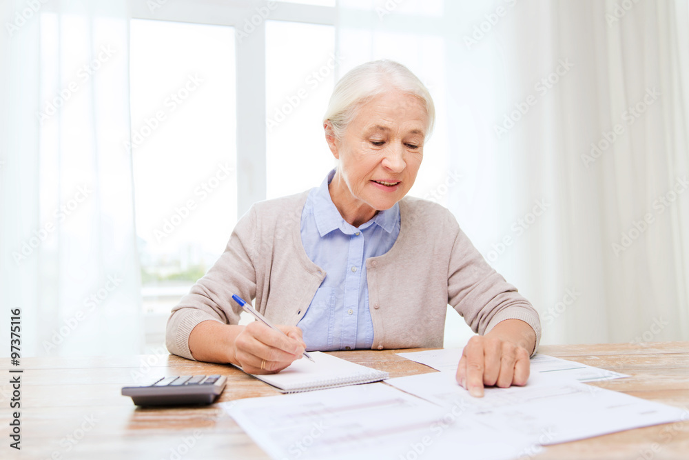 senior woman with papers and calculator at home senior woman with papers and calculator at home