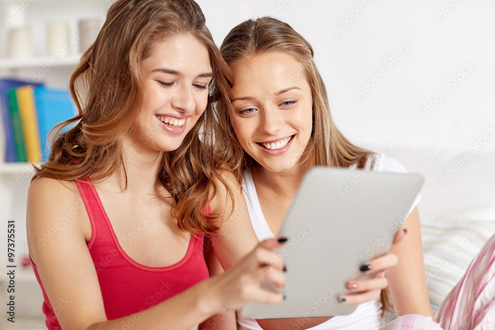 happy friends or teen girls with tablet pc at home happy friends or teen girls with tablet pc at home