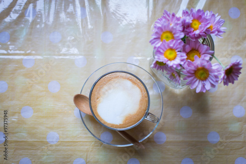 hot coffee and bouquet of flower on grunge wood table.