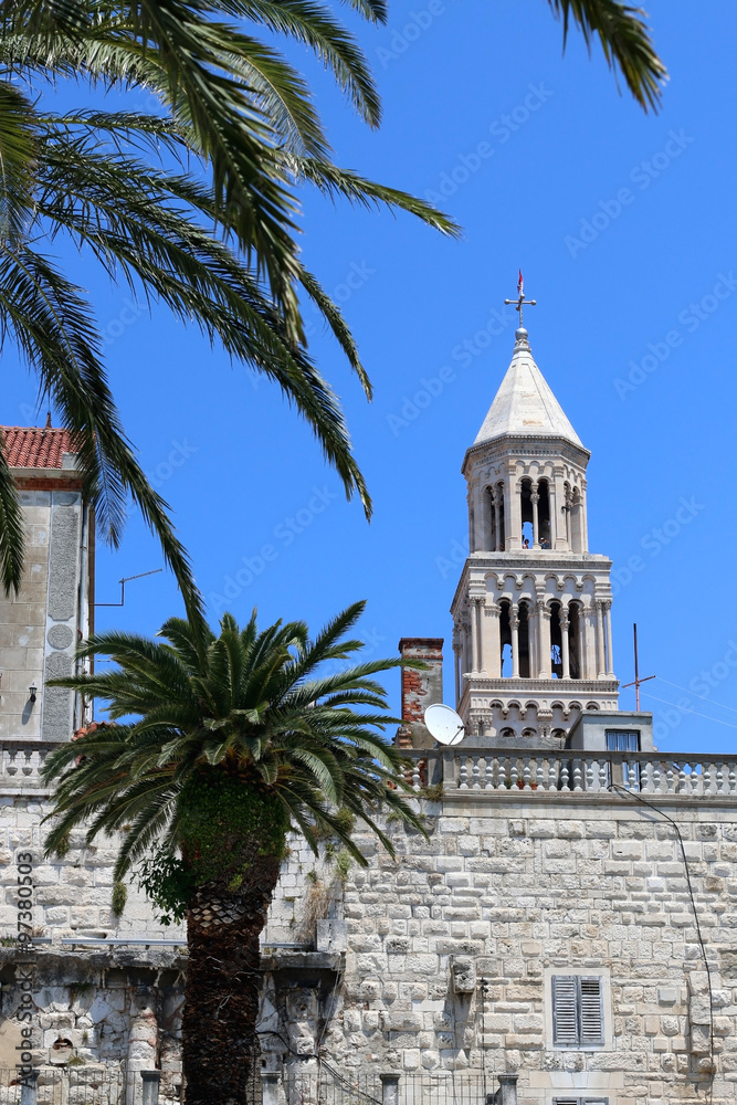 Saint Domnius bell tower surrounded by palm trees. Landmark in Split, Croatia. Split is famous touristic destination and UNESCO World Heritage Site. 