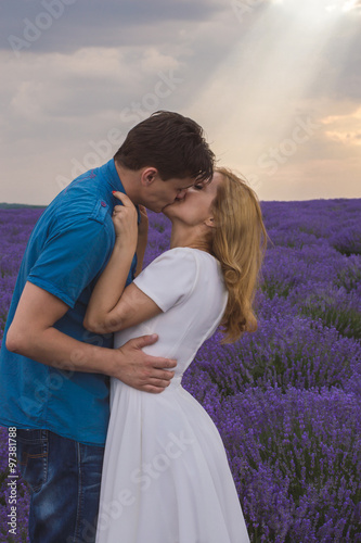 Happy young couple kissing each other on lavender field