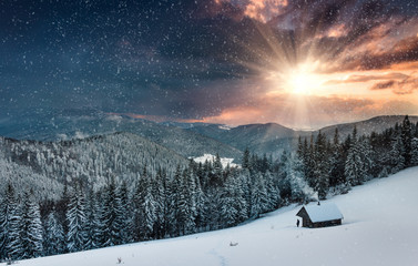 Colorful winter evening in the mountains at sunset. View of the old farm and tourist near.