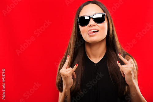 Beautiful young fashion girl having fun on a red background