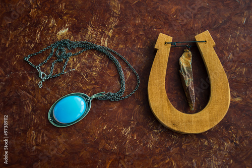 деревянная подкова и ожерелье лежат на столе