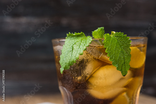Cuba libre with lime on black wooden table
