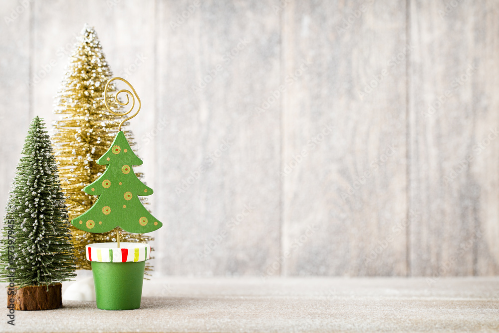 Artificial Christmas tree on a wooden background. - obrazy, fototapety, plakaty 