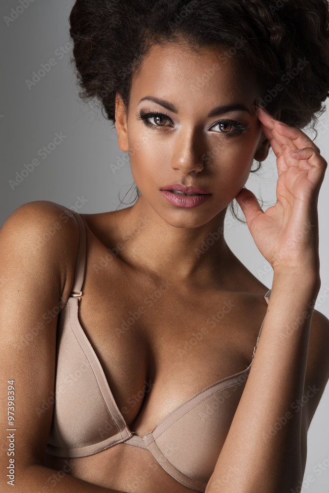 Afro sexy woman posing in black lingerie, looking at camera.