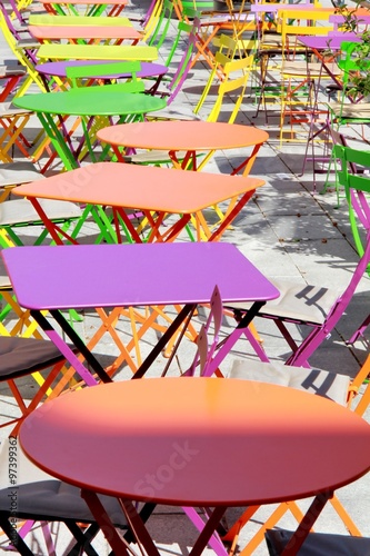 Des tables rondes et carr  es de toutes les couleurs sur une terrasse en ext  rieur