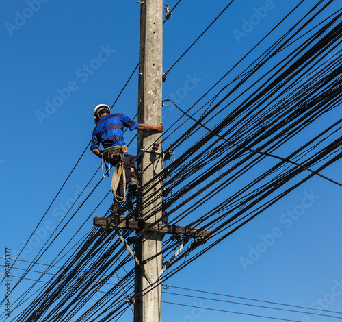 electrician working on electric power pole 