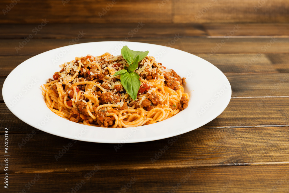 Spaghetti bolognese with cheese and basil on a plate Spaghetti bolognese with cheese and basil on a plate