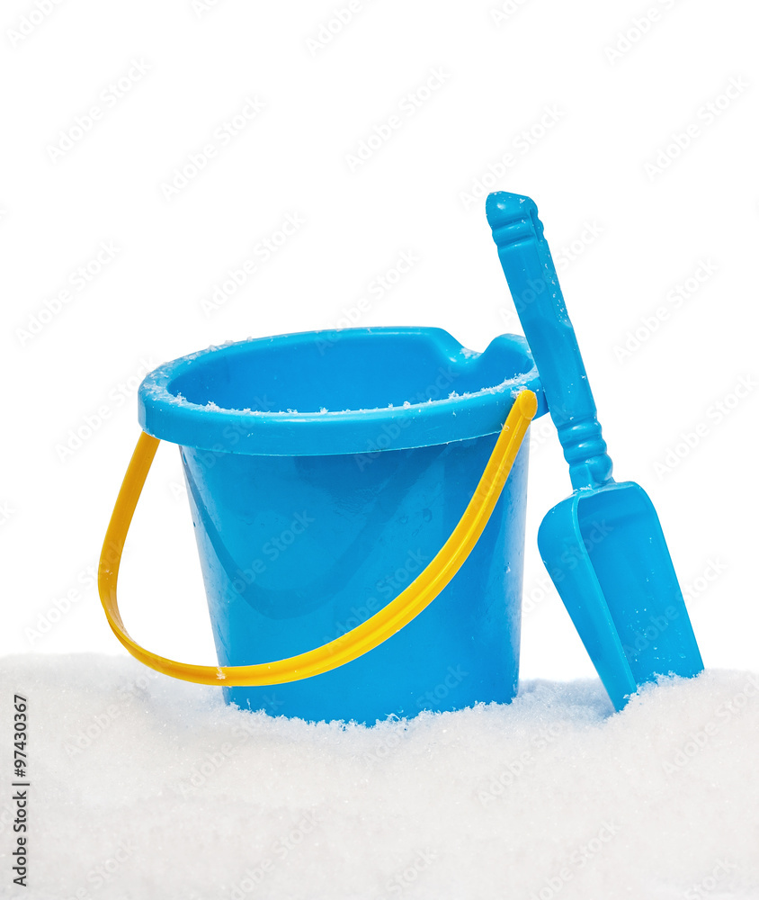 The blue yellow bucket and shovel which are filled up with snow, covered snow, isolated on the white The blue yellow bucket and shovel which are filled up with snow, covered snow, isolated on the white