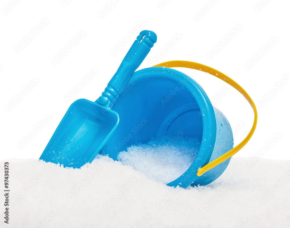 The blue yellow bucket and shovel which are filled up with snow, covered snow, isolated on the white The blue yellow bucket and shovel which are filled up with snow, covered snow, isolated on the white