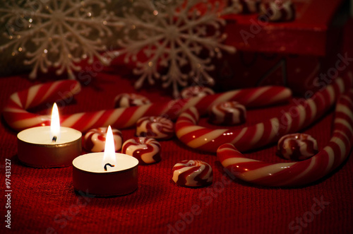 Christmas composition with red and white candy and candles