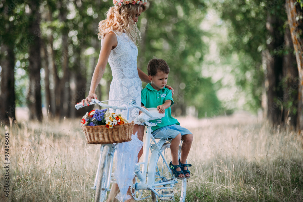 Obraz premium beautiful woman rolls the baby on the big bike