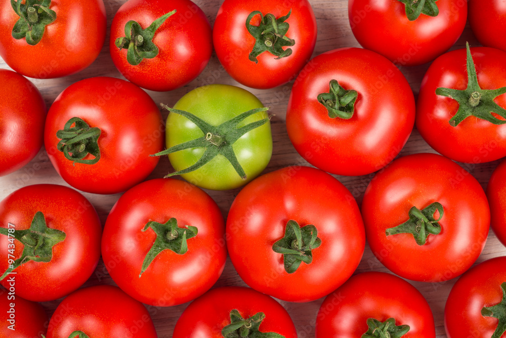 many fresh red tomatoes, one green, background top view many fresh red tomatoes, one green, background top view