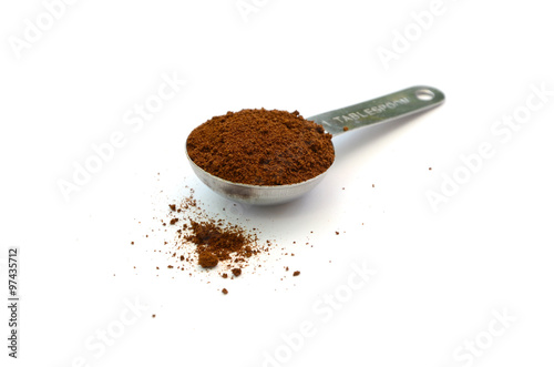 ground coffee and silver table spoon isolated in white background