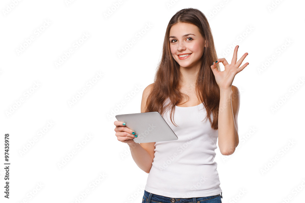 Attractive smiling girl in white shirt using tablet showing okay sign. Woman with tablet pc, isolated on white background Attractive smiling girl in white shirt using tablet showing okay sign. Woman with tablet pc, isolated on white background