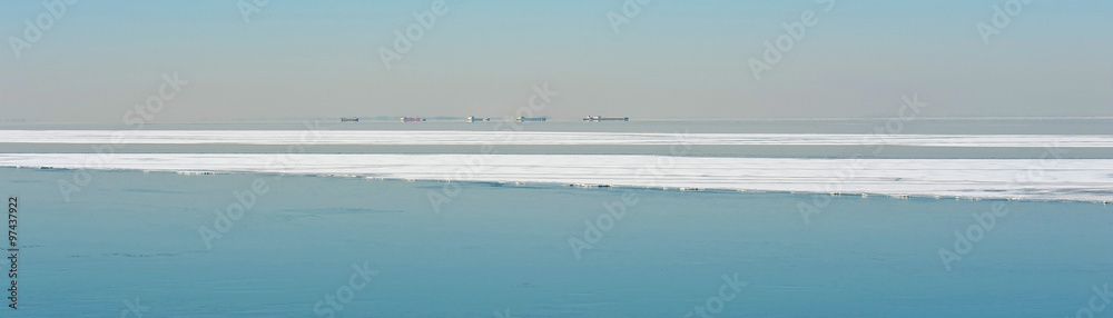Boats sailing along an ice sheet in winter Boats sailing along an ice sheet in winter