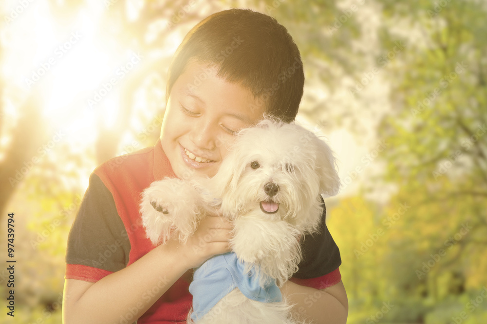 Little boy hugging his dog on the park Little boy hugging his dog on the park
