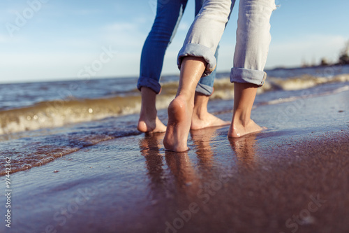 feet of couple woman and man in the sea waves