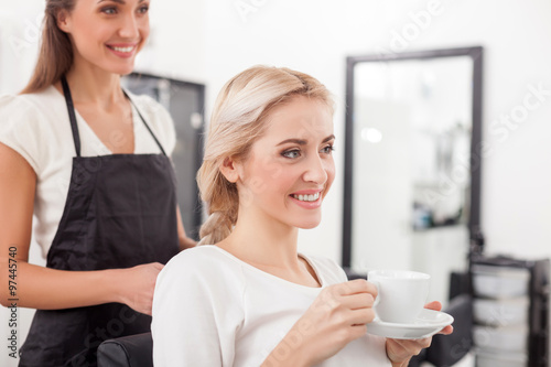Beautiful blond girl is attending hairdressing saloon