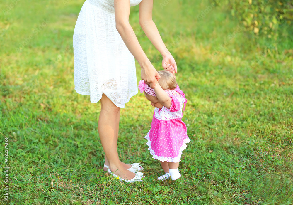 Beautiful mother and baby walking together on grass in summer da Beautiful mother and baby walking together on grass in summer da