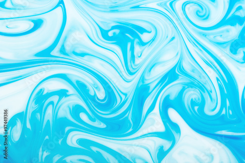 Blue ink flowing in milk texture.