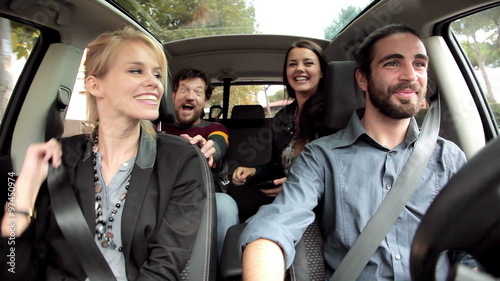 Four friends laughing driving car happy