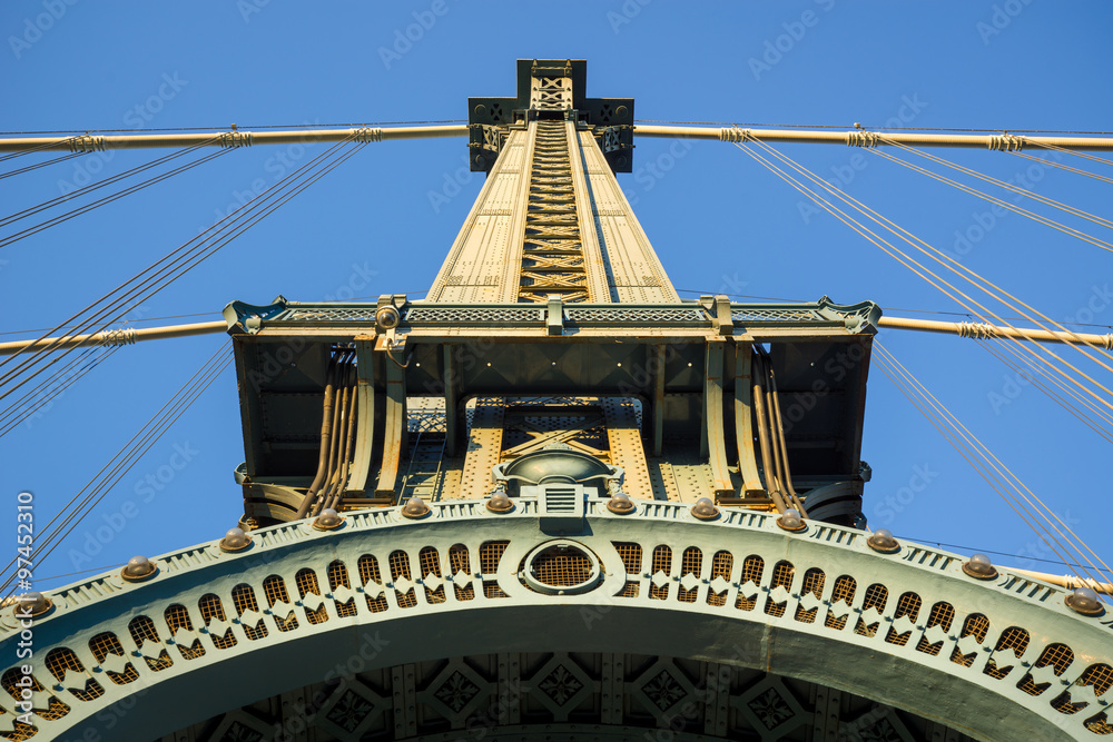 Naklejka premium Beaux-Arts style architectural detail of painted steel tower of the Manhattan Bridge. The long-span suspension bridge crosses New York City’s East River linking Downtown Manhattan and Brooklyn.