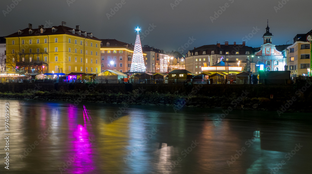 Innsbruck Marktplatz Christmas market, night view with colors reflections in the Inn river.