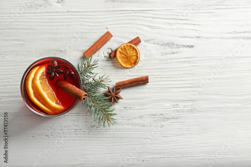 Mulled wine with cinnamon on wooden table