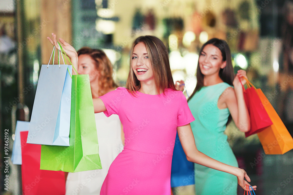 Beautiful young women with bags in shopping center Beautiful young women with bags in shopping center