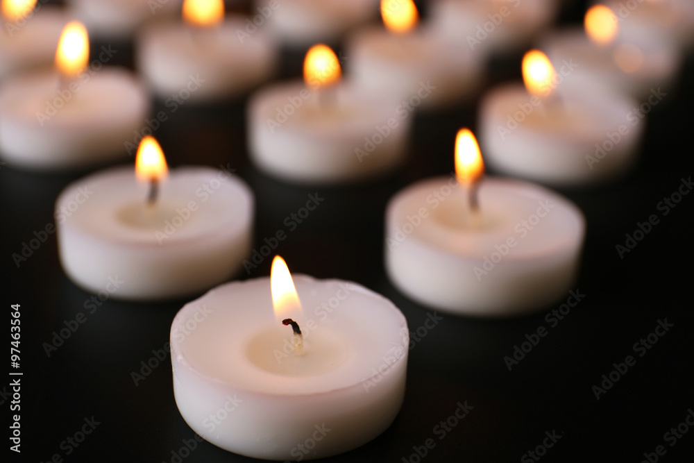 Alight candles in a row on black background Alight candles in a row on black background